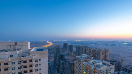 Wall Mural - Cityscape of Ajman from rooftop night to day timelapse. Ajman is the capital of the emirate of Ajman in the United Arab Emirates.