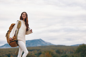 Wall Mural - Mountain Adventure: Smiling Woman Enjoying Backpacking on Cliff