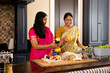 © Wavebreak Media - Indian mother and teenage daughter preparing food together at home