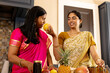 © Wavebreak Media - Indian mother in pink sari and teenage daughter in yellow sari preparing food at home