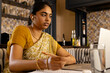 © Wavebreak Media - Indian young woman wearing traditional clothing, working on laptop at home