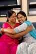 © Wavebreak Media - Indian mother and teenage daughter in traditional attire, laughing and hugging at home