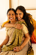 © Wavebreak Media - Indian mother, daughter in sarees embrace warmly at home
