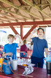 Boys share laughs holding crawfish at a sunny picnic