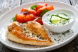 Seared chicken breast and tzatziki on wooden table

