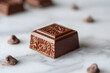 A single piece of chocolate. Its rectangular shape is perfectly formed, each edge crisp and well-defined