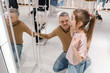 Father and Daughter Enjoying a Fun Moment at a Clothing Store Mirror