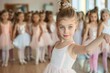 © Pinklife - A young ballerina leads a dance class while confidently performing ballet poses