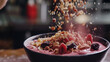 A dynamic shot capturing the moment a handful of mixed nuts and dried fruits is sprinkled onto a smoothie bowl, adding a nutritious and flavorful topping.