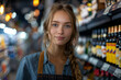 © S photographer - A Caucasian female employee in an apron manning the liquor shelves in a department store is looking confidently at the camera.