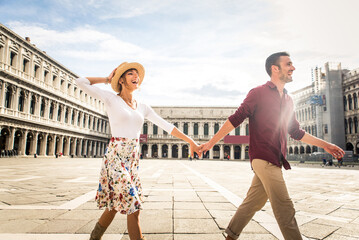 Happy cheerful young ouple travelling in Venice, Italy - Tourists visiting the historic city of Venice