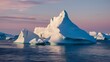 A breathtaking view of icebergs floating on calm waters during what appears to be either dawn or dusk. The icebergs are predominantly white, with some exhibiting shades of blue