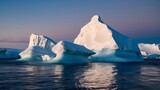 Fototapeta Lawenda - A breathtaking view of icebergs floating on calm waters during what appears to be either dawn or dusk. The icebergs are predominantly white, with some exhibiting shades of blue