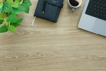 Wall Mural - Laptop computer, coffee cup and notebook on wood background. Top view.