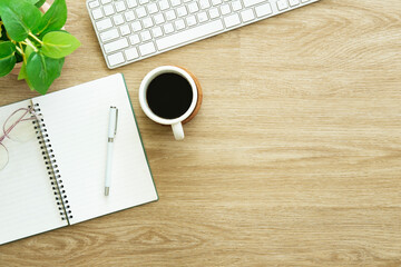 Wall Mural - A cup of coffee, notebook, glasses and headphone on wooden table. Top view with copy space.
