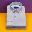 Three folded men's shirts on a colored background