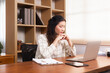 © Rakchanok - Young Asian woman in casual using a laptop working at home in living room, thoughtful freelance businesswomen sitting in office, small business architect entrepreneur concentrated planning on computer