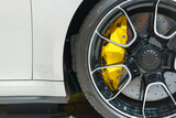 Fototapeta  - Alloy wheel with calipers and racing brakes of the sport car.