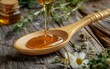 A spoonful of honey is poured into a wooden spoon