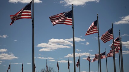 Ring of flags flying at the Washington Monument in Washington DC on a sunny day with blue sky.