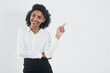 © peopleimages.com - Pointing, happy and portrait of business black woman on a white background for promotion in studio. Advertising, professional and isolated person with gesture for announcement, news and information