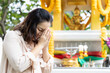 Happy middle aged woman praying at Brahman God Shrine and winning her wish, wish fulfilling pilgrimage