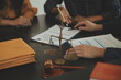 © Kansuda - Justice and Law concept. Legal counsel presents to the client a signed contract with gavel and legal law or legal having team meeting at law firm in background