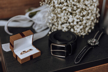 Wall Mural - A wedding ring and a watch are displayed on a table