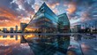 The image displays a modern urban landscape at dusk, featuring striking glass buildings with a geometric design that glisten under the ambient light. The skyline is adorned with a beautiful, vibrant s