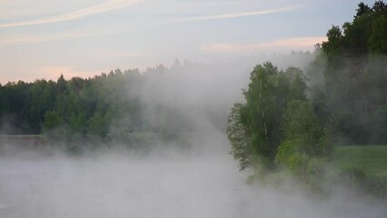 Poster - The water is foggy and the sky is cloudy. The mist is rising from the water. The scene is peaceful and serene