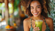 Healthy caucasian woman smiling while enjoying drinking a vegan green juice or smoothie made with organic vegetables.