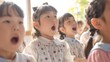 © kittipoj - Enthusiastic Japanese Schoolchildren Reciting Language Alphabet Characters in Bright Sunny Classroom