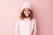 © MediaRaw - A young girl wearing a pink hoodie and a pink hat is smiling