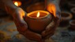 A pair of hands carefully molding a piece of clay into a small cup destined to hold a flickering candle..