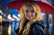 Portrait of a smiling blonde girl with blue eyes in the evening city in rainy weather.