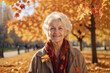 Portrait of a smiling elderly woman, a pensioner in an autumn park in sunny weather