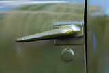 Fototapeta Dmuchawce - Door handle of a retro lorry truck. metal, door painted green khaki