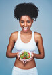 © peopleimages.com - Smile, portrait or black woman with salad in studio for healthy meal, nutrition diet or digestion benefits. Body, vegetables and happy female fitness model eating food isolated on blue background