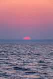 Fototapeta Góry - dawn over the sea, yellow-red sun close-up