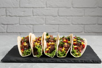 Sticker - Delicious tacos with meat and vegetables on light gray marble table against brick wall