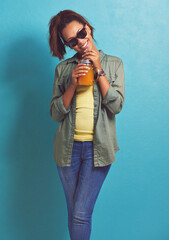 Sticker - Happy woman, portrait and sunglasses with orange drink in fashion for vitamin C or diet on a blue studio background. Female person, brunette or model with smile for citrus juice or fresh beverage