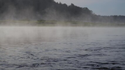 Poster - The water is foggy and the sky is cloudy. The mist is rising from the water. The scene is peaceful and serene