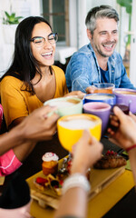 Wall Mural - Group of young people having breakfast together toasting coffee at rooftop bar terrace