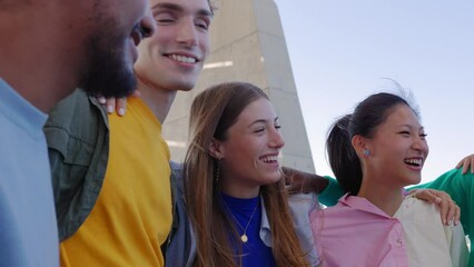 Wall Mural - Mixed-race young people having fun together embracing each other outdoor. Student teenage friends laughing while hanging out outside. Youth community concept.