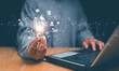 © krungchingpixs - Artificial Intelligence concept, Innovative AI technology for business, Businessman use laptop and holding lightbulb with Ai and icon of financial technology and business administration, Chat with AI.