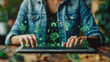© mimi - Eco-Strategy Interface: A person in a denim shirt uses a laptop with floating sustainability icons like a plant light bulb, recycling symbol, and a house with a leaf, emphasizing green initiatives.