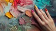 © Jenjira - Artistic allure A hand with vivid nails among levitating palettes, against a tranquil, ash grey scene