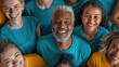people of varying ages, races, and genders, all wearing a blue-green or yellow t-shirt, all smiling