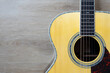 close up acoustic guitar on wooden table background, music concept