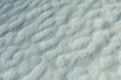 Texture of snow. Melted snow in winter in sun. Surface is wavy.